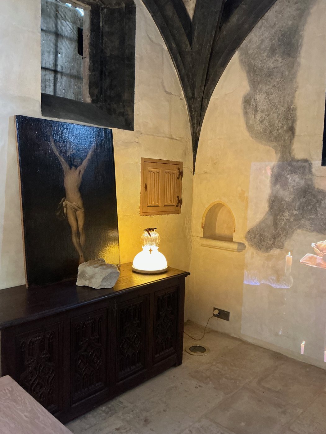 Foi, la lampe à la petite croix suspendue, dans la chapelle voûtée du château des Milandes, près d'un Christ en croix